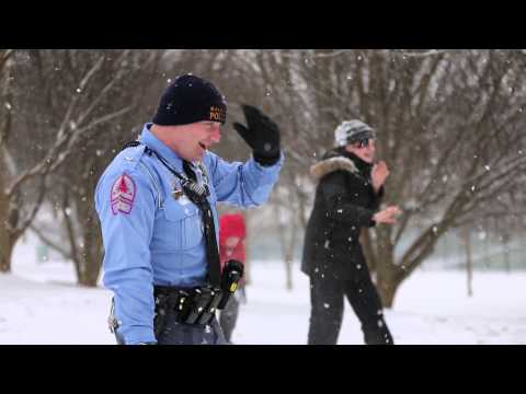 شرطي يشارك الأطفال اللعب بالثلج